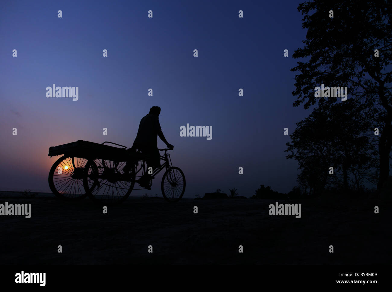 Silhouette of a man on his tricycle in South Bangladesh Stock Photo