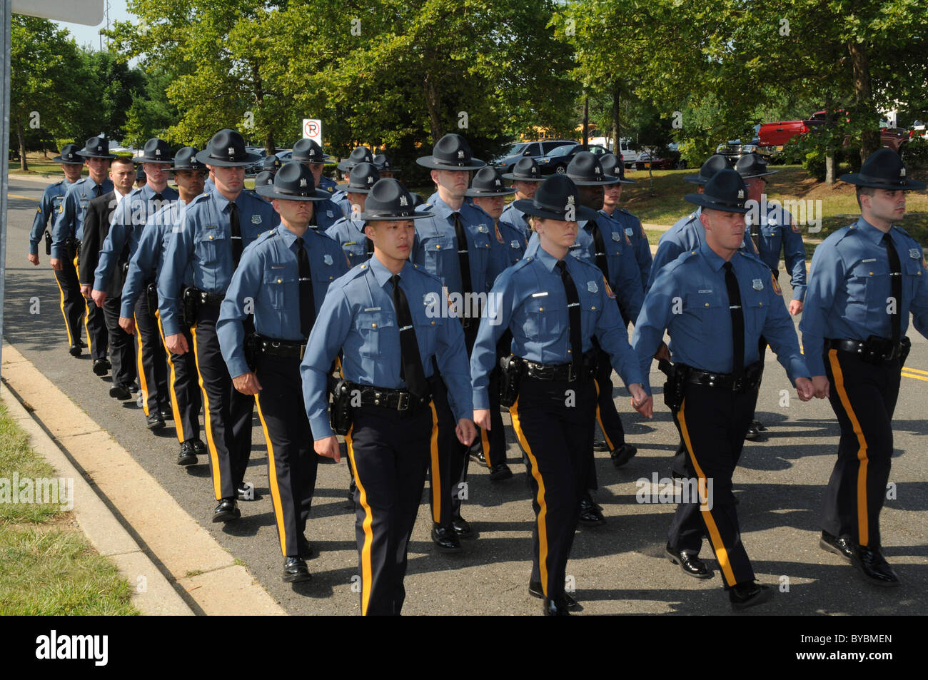 Police officers march down the street to a church where a funeral for a Maryland State Trooper who was shot and killed was held Stock Photo