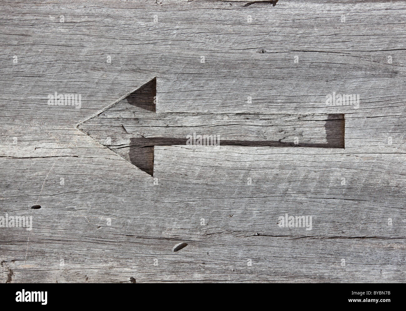 carved arrow left in timber Stock Photo