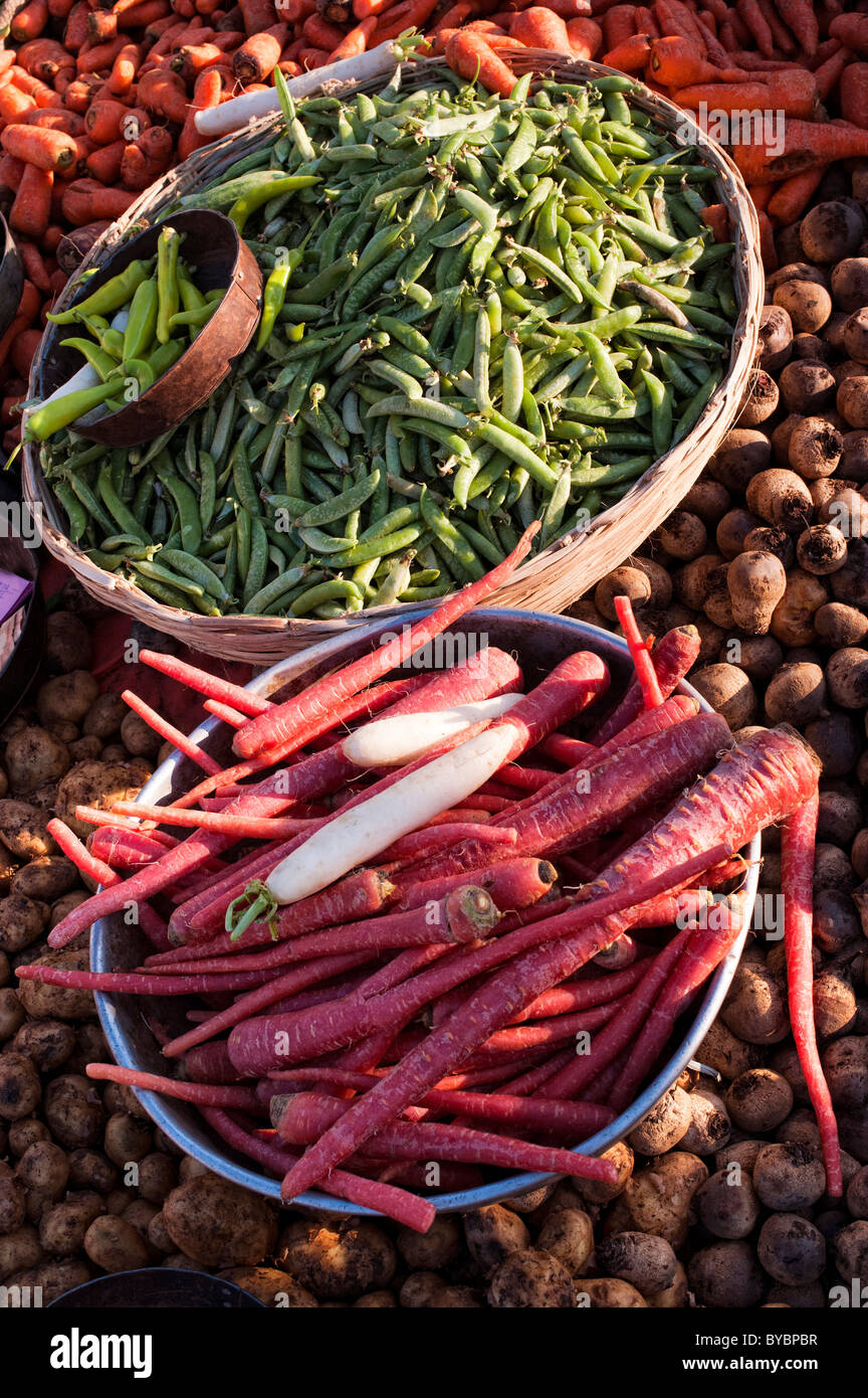 Basket of peas and long red carrots at an indian vegetable market