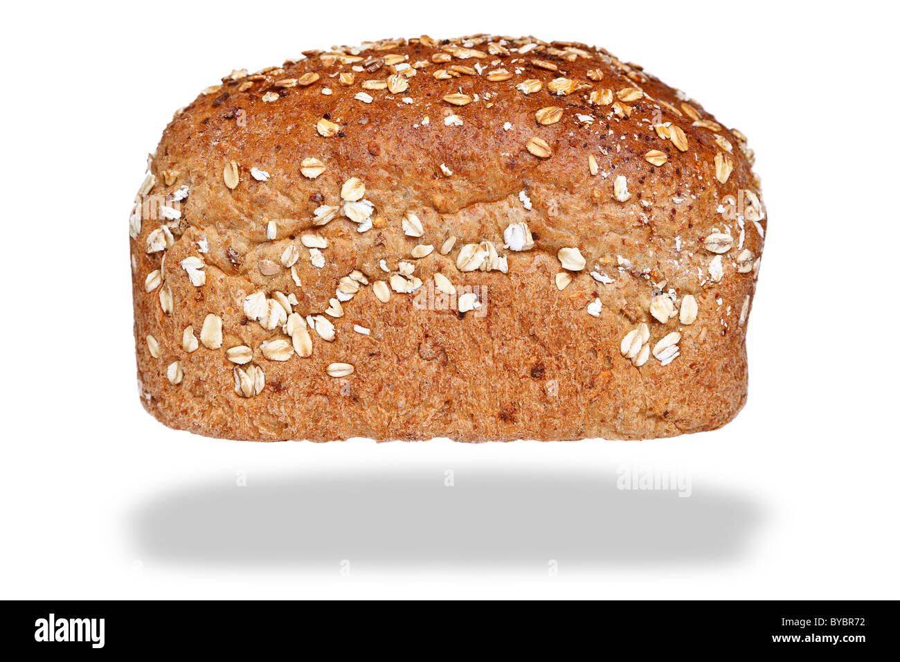 Photo of a loaf of wholemeal bread covered in oats, isolated on a white background with floating shadow. Stock Photo
