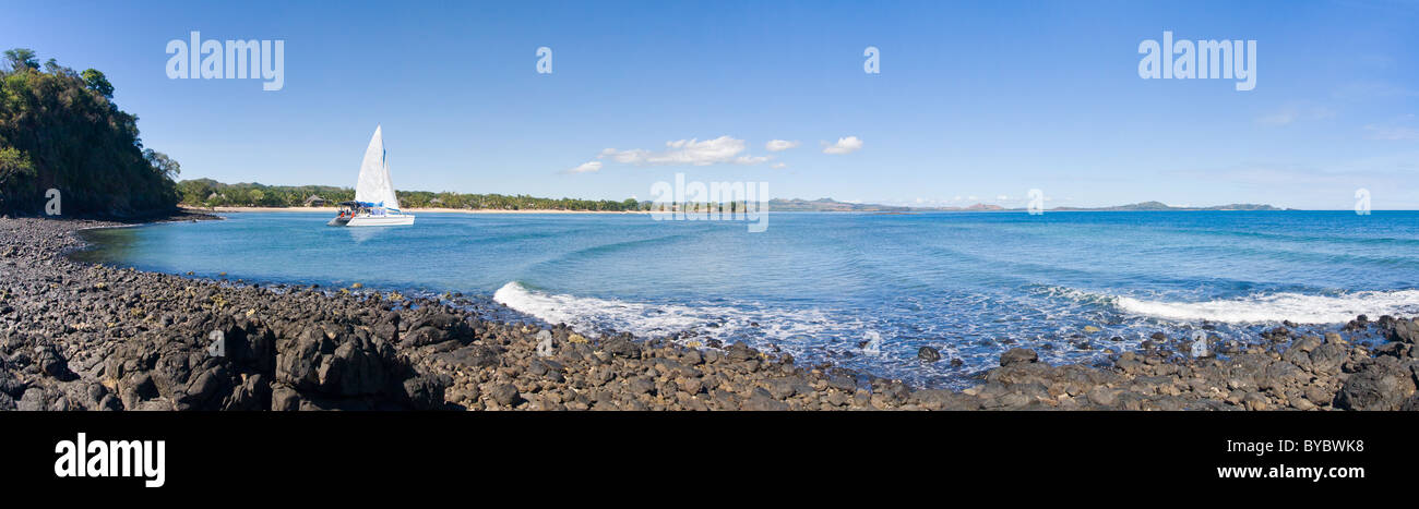 Rochy beach panorama with catamaran sailboat Stock Photo - Alamy