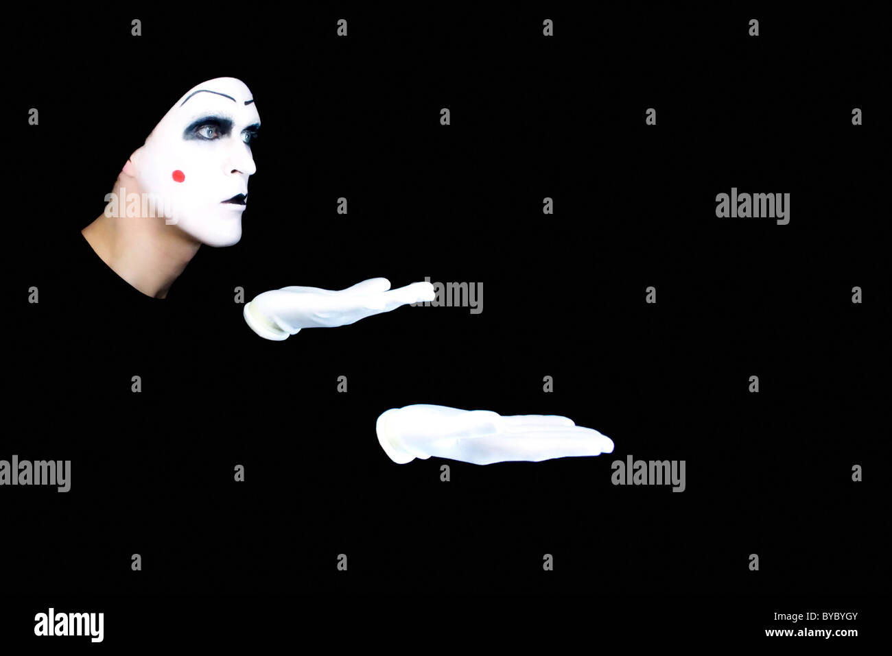 Portrait of the mime in white gloves on a black background Stock Photo