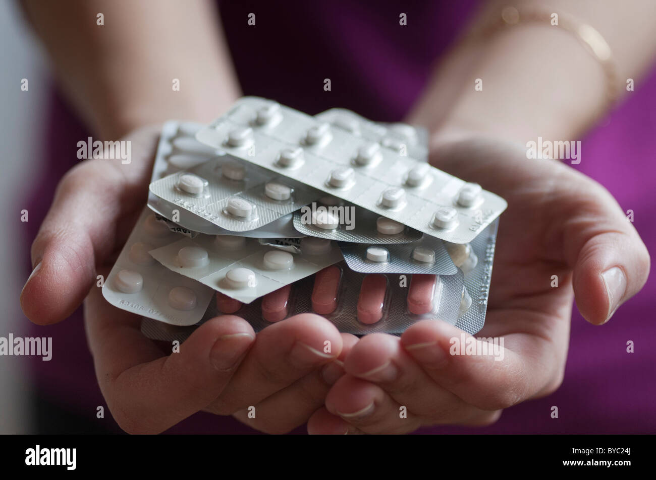 Woman holds variety of  prescription drugs in her hands Stock Photo