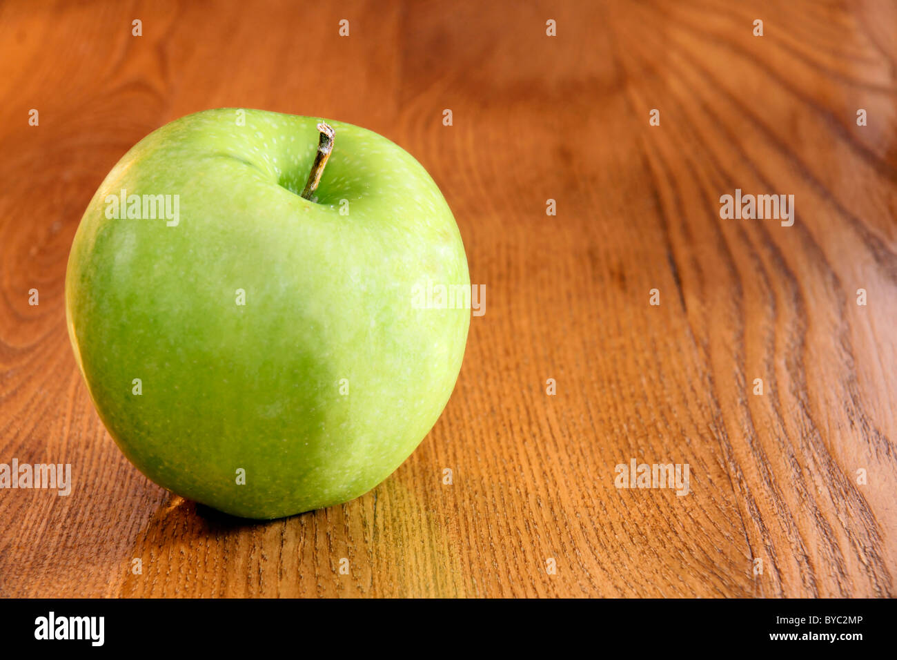 Healthy food vibrant green granny smith apple on wooden kitchen table