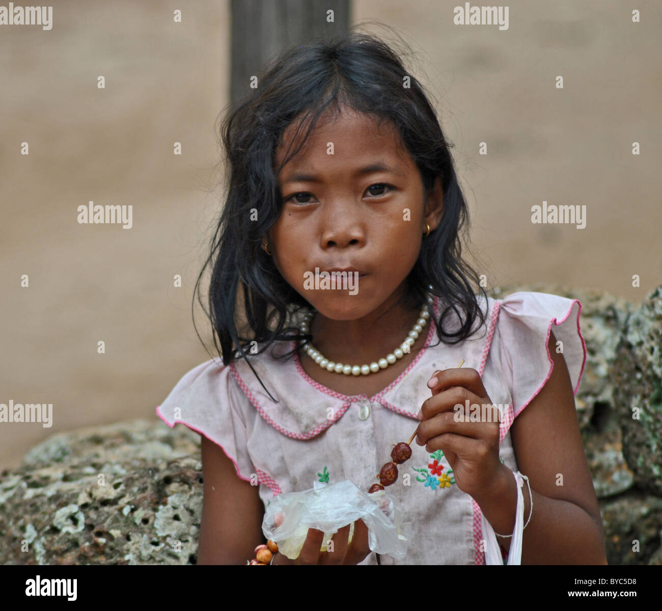 Cambodian girl eating toffees Stock Photo