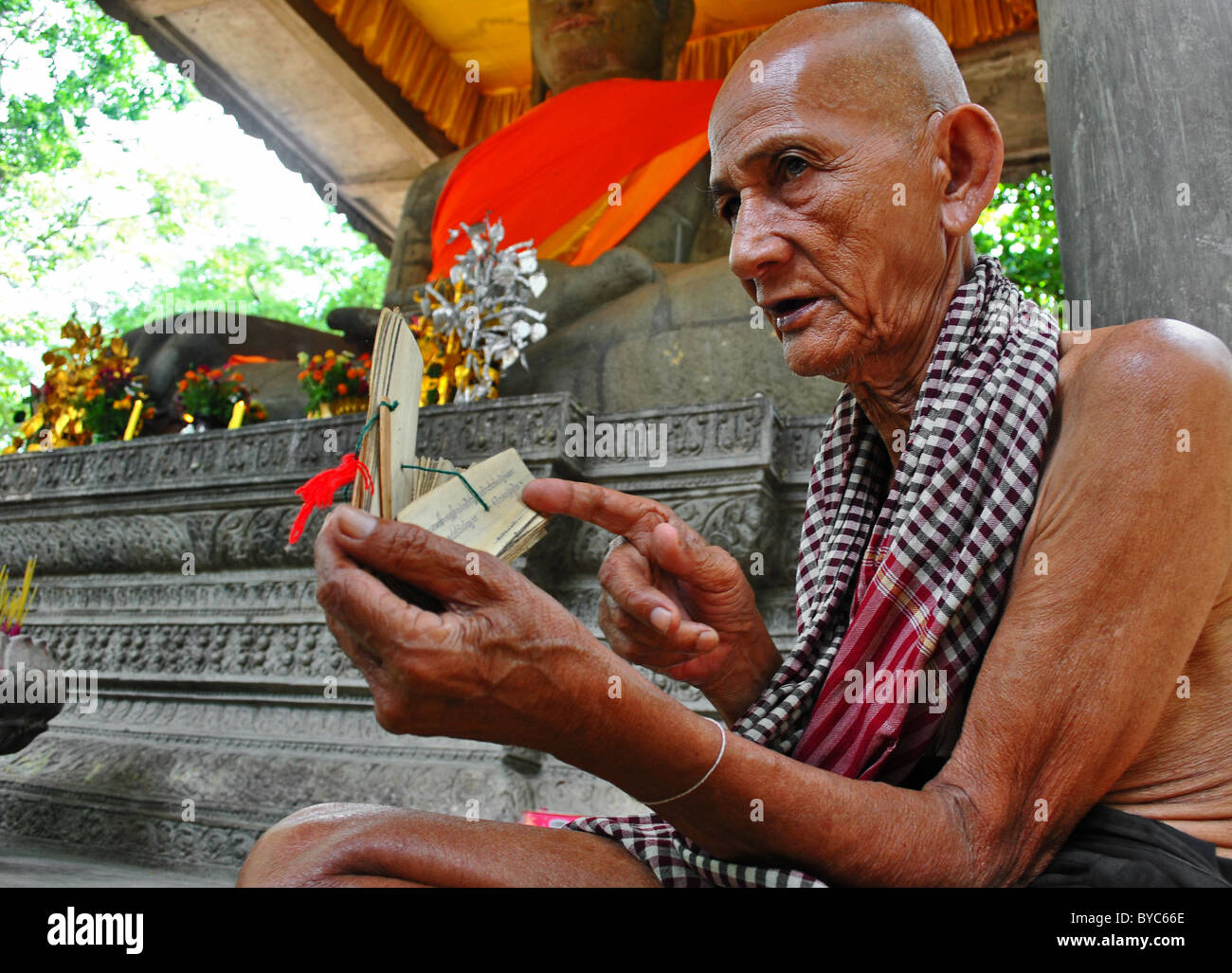 Elderly Cambodian monk reading scripts, Angkor Thom Temple, Cambodia Stock Photo