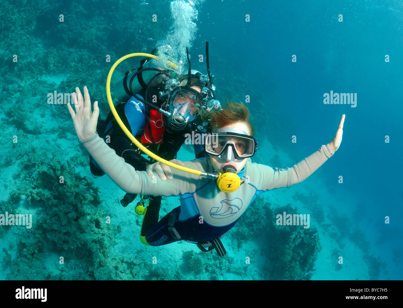 Scuba diver in full face diving mask shows the child the underwater world Stock Photo