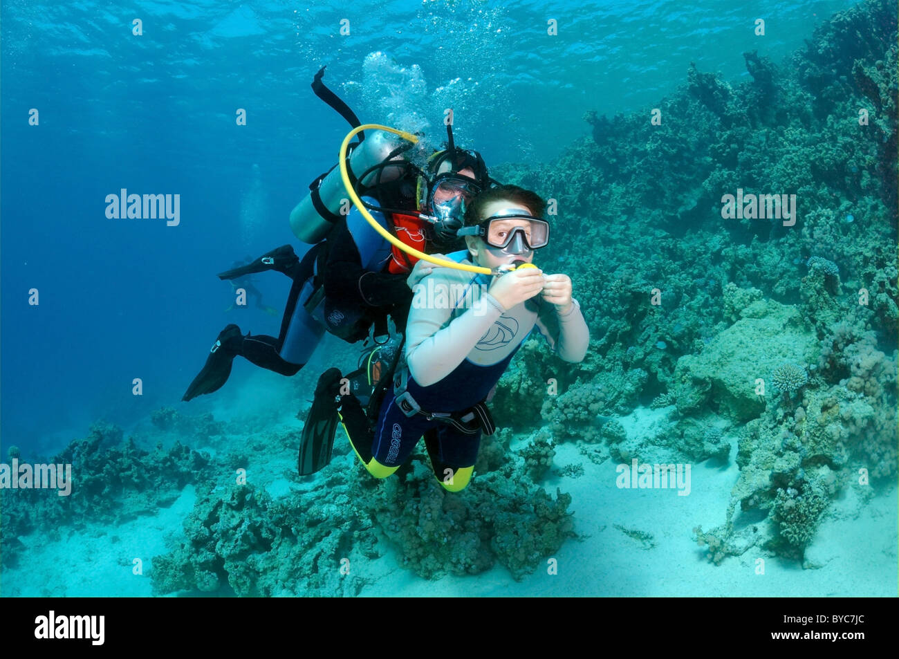 Scuba diver shows the child the underwater world Stock Photo