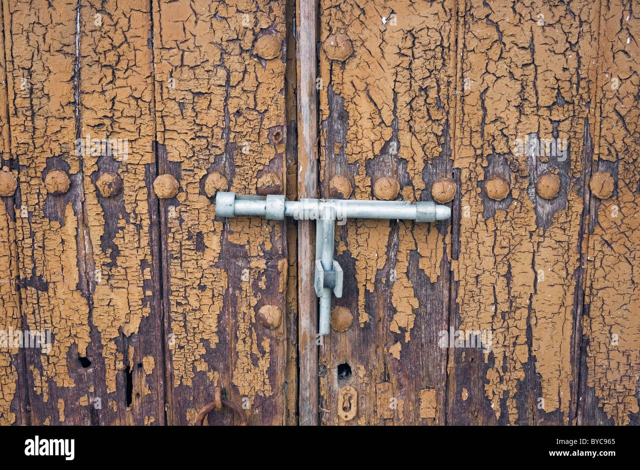 Bolt on old peeling wooden door Stock Photo