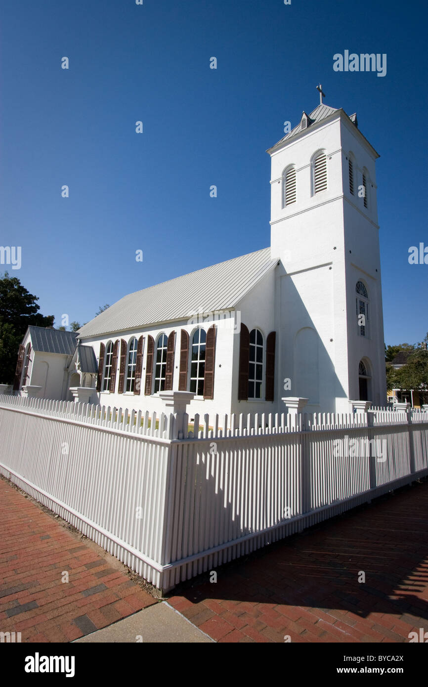 An old country church is surrounded by a white picket fence. Stock Photo