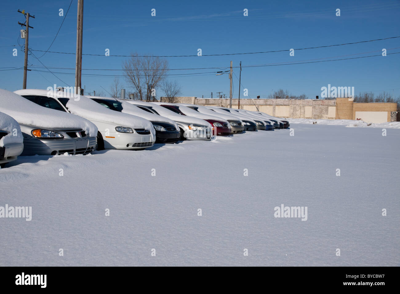 Snow-covered automobiles in Automobile Dealership parking lot Michigan USA Stock Photo