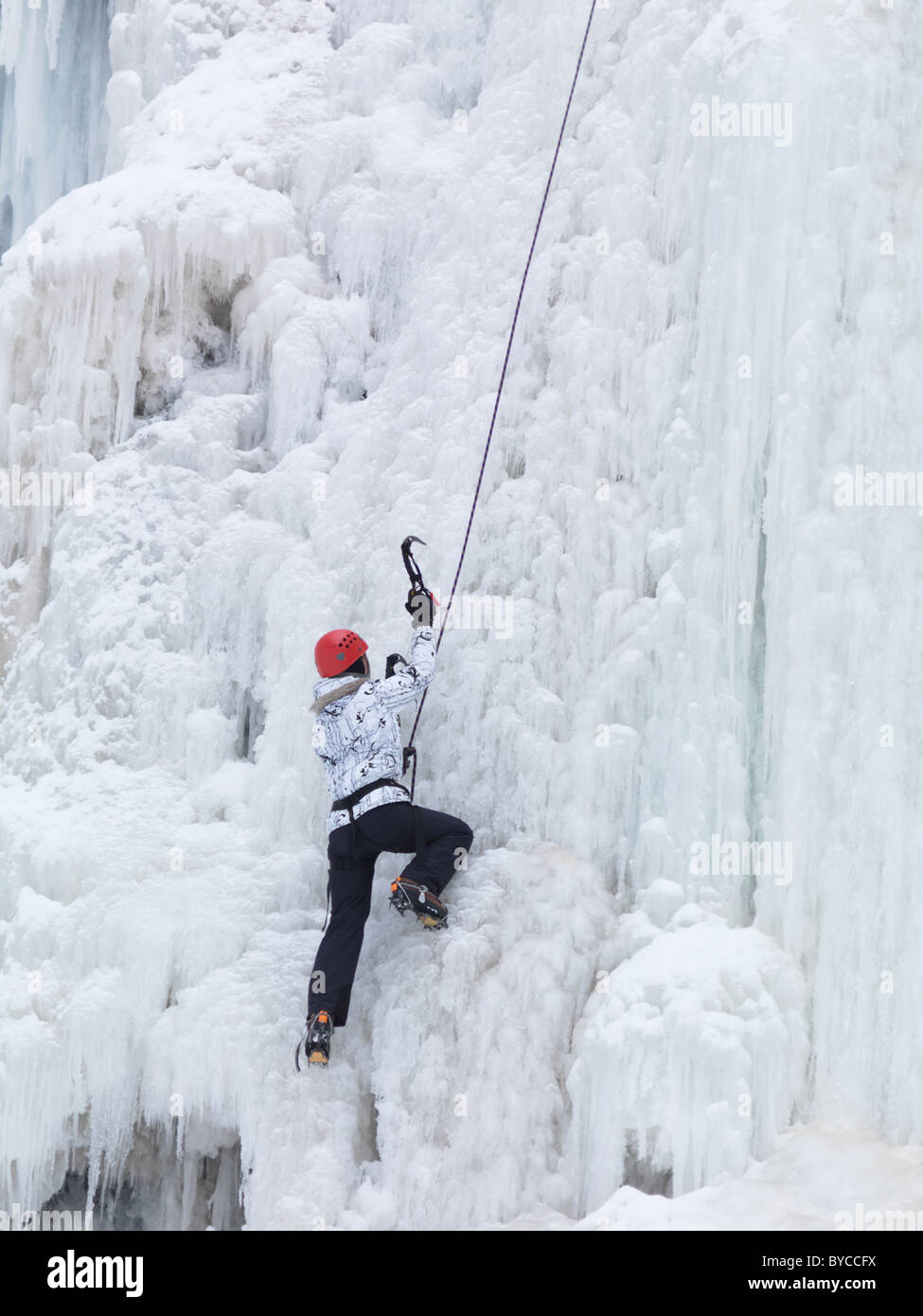 Ice climber climbing a frozen waterfall. Wintertime scenic, Ontario, Canada. Stock Photo