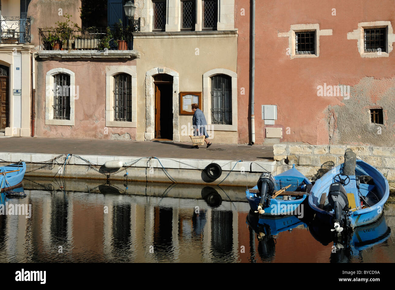 Woman Walking Along Canal Quayside with Terraced Housing, Île Brescon or Island, Martigues ('the Venice of Provence'), France Stock Photo