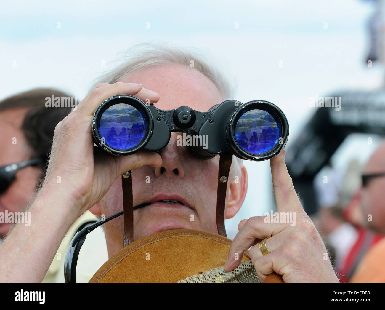 Spectator looking through binoculars at the sailing races during Cowes Week on the Isle of Wight, England, UK Stock Photo