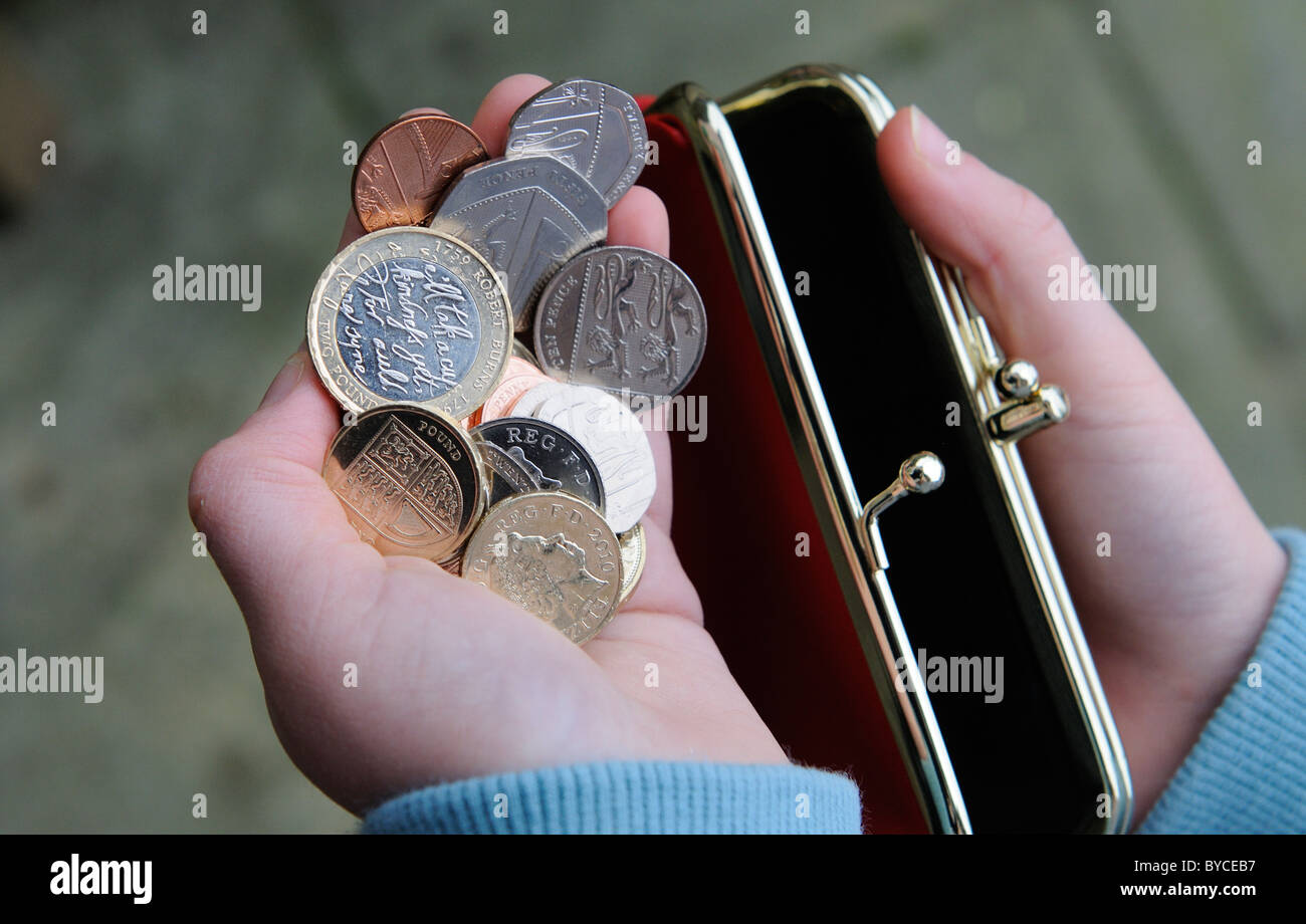 Child's hand with a red purse and British money Stock Photo