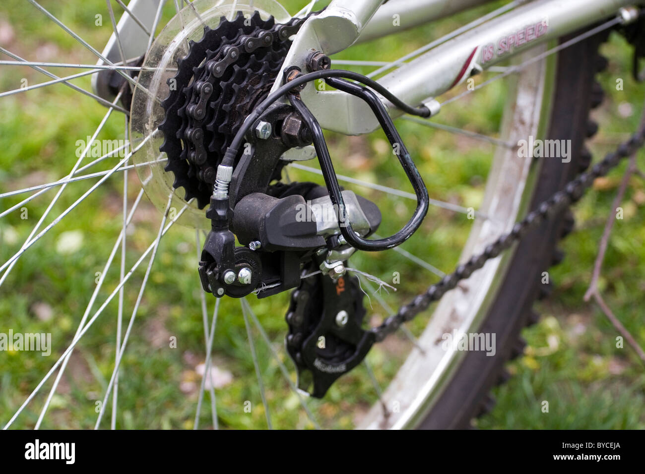 Rear Derailleur and chain on an 18 speed bicycle with metal guard and sprocket. Stock Photo