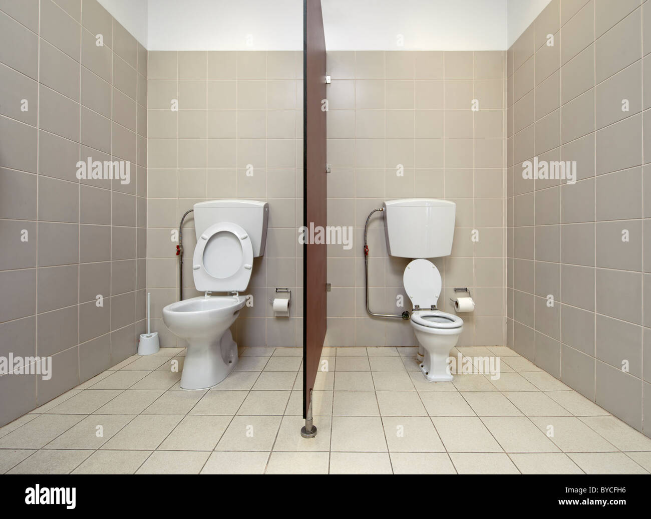 Full size toilet next to kid's toilet at a preschool bathroom Stock Photo