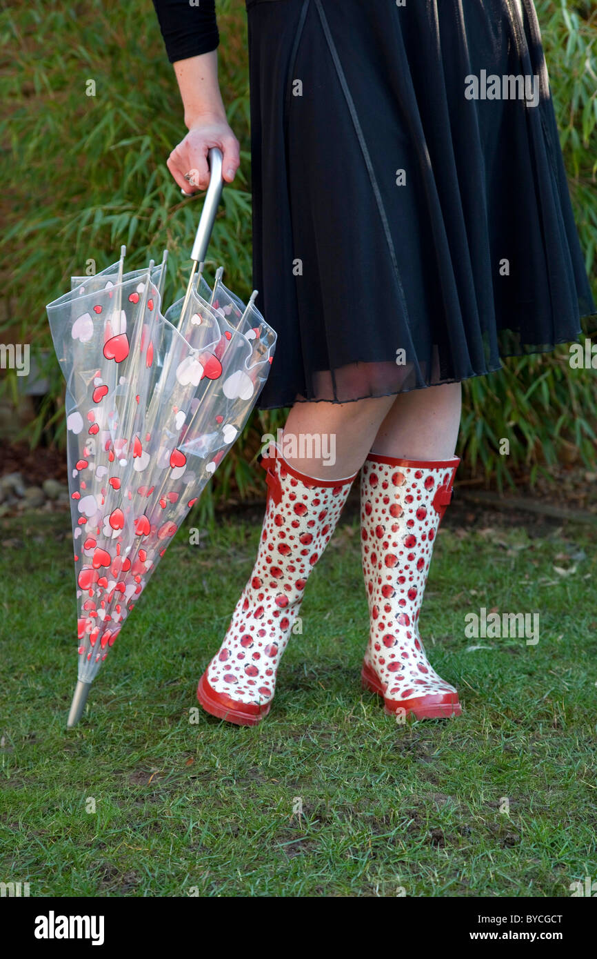 Woman wearing wellies and holding umbrella Stock Photo