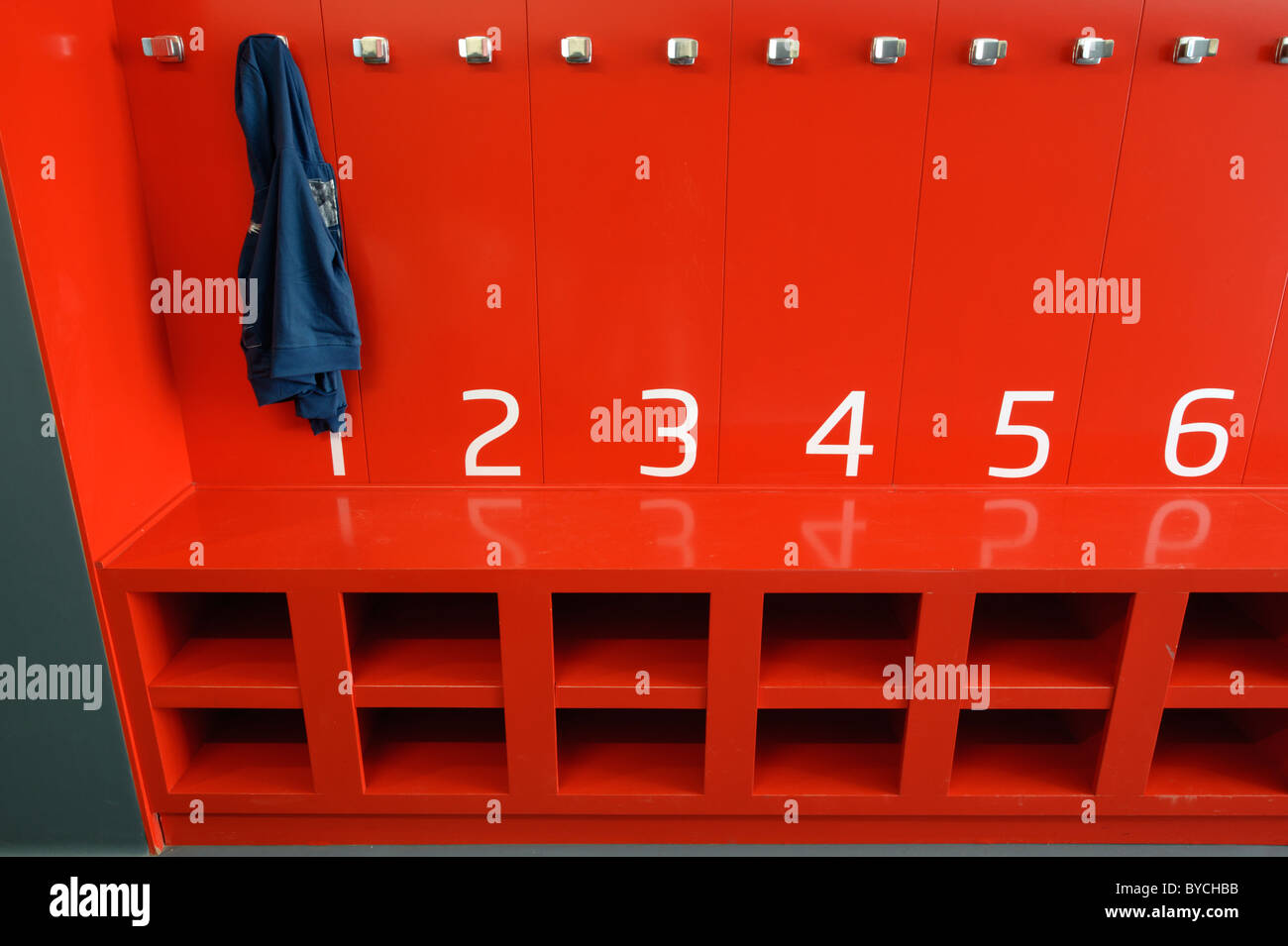 School red cloak room with blue coat hanging Stock Photo