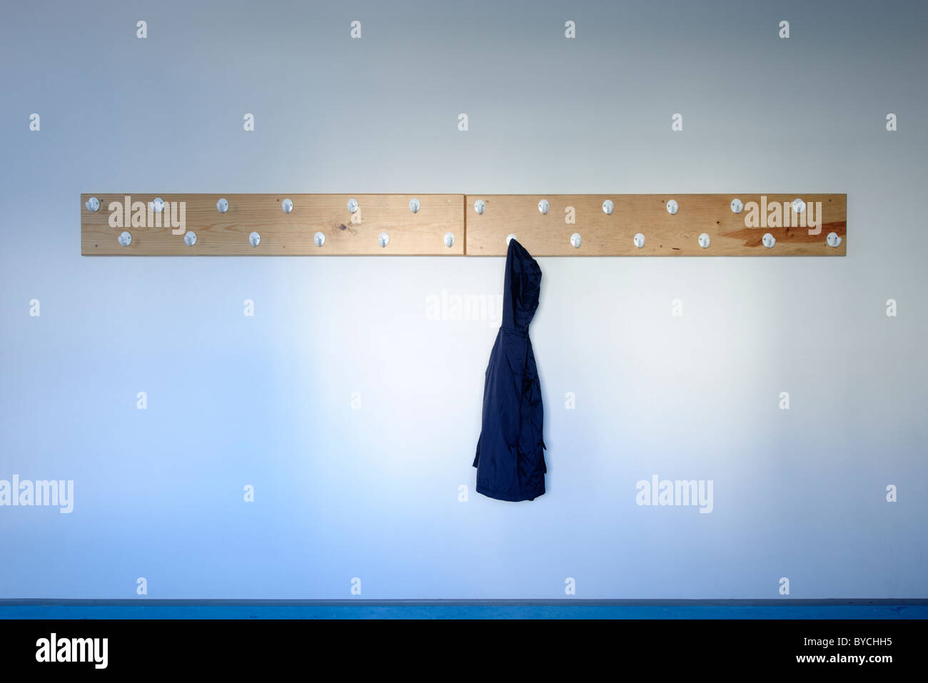 School cloak room with blue coat hanging Stock Photo