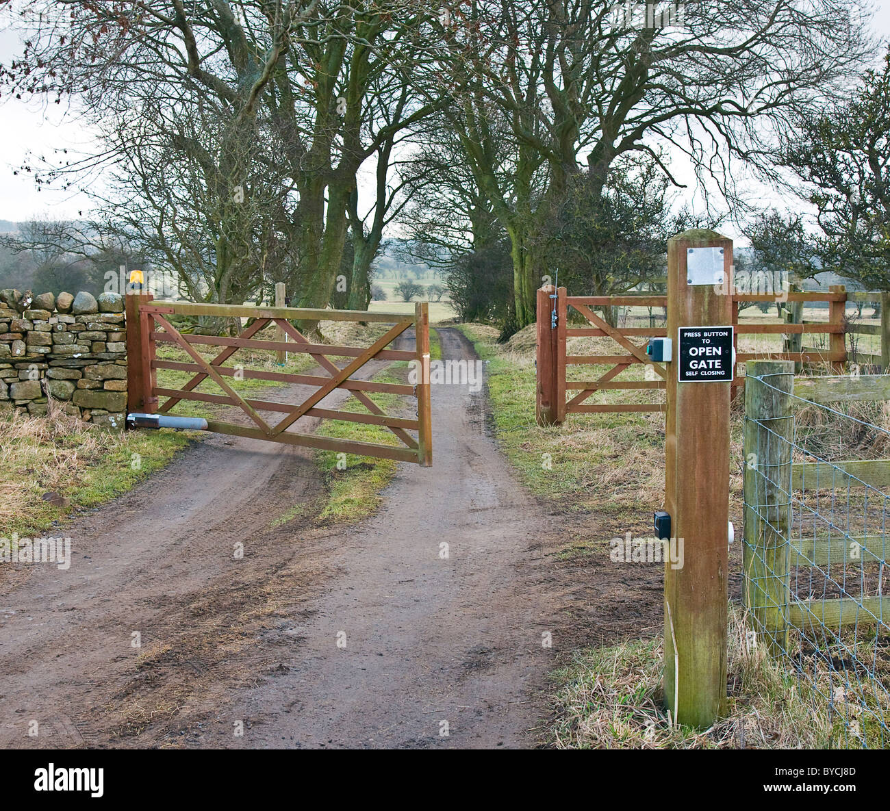 country lane with a self closing electric gate. Stock Photo