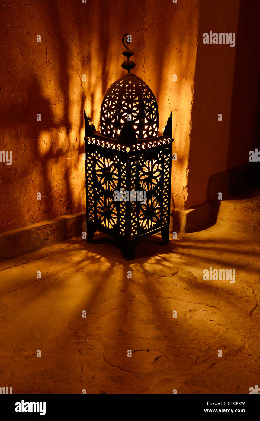 Traditional lantern glowing on walls at night inside Kasbah Ait Ben Moro at Skoura Morocco Stock Photo