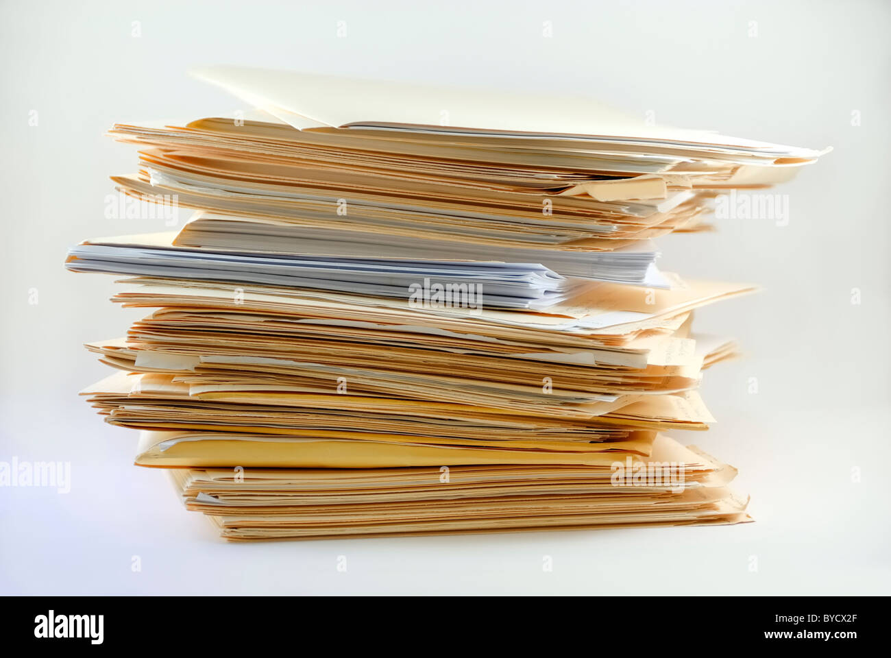 Stack of manila work file folders used in accounting or for business record keeping. They are stacked upon each other in a tall stack. Stock Photo