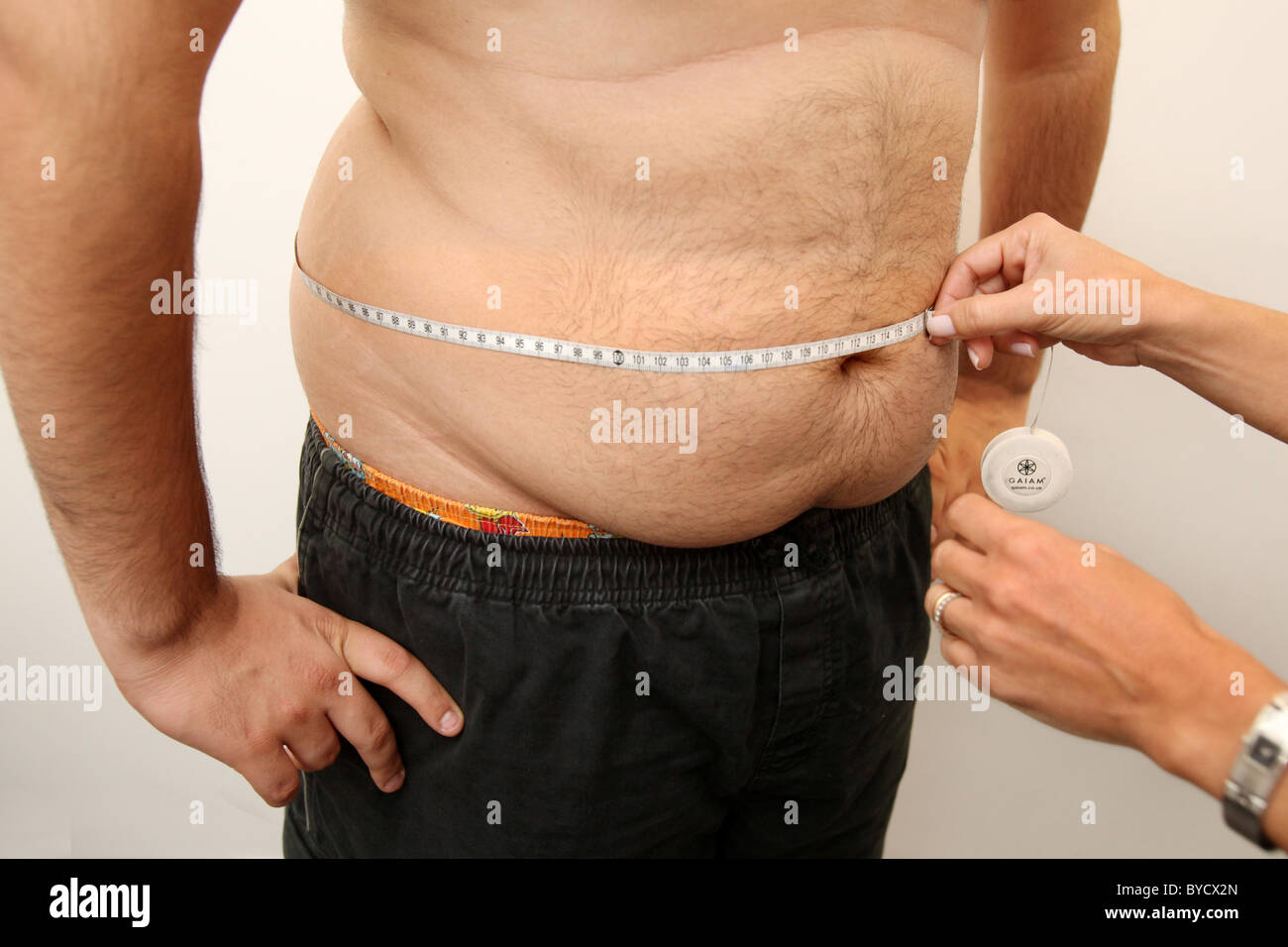 Woman measuring man's waist. Stock Photo
