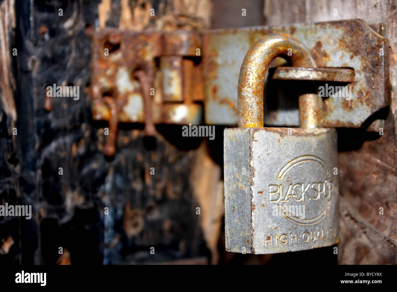 A padlock by Blackspur on an old wooden door held in by nails Stock Photo