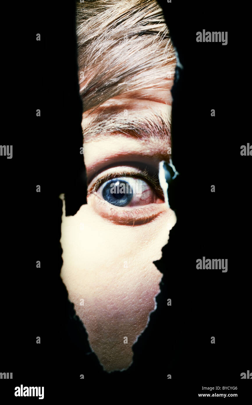 Scary eyes of a man spying through a hole in the wall Stock Photo Alamy