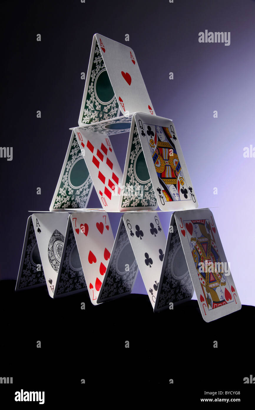 Pyramid of playing cards. 14 cards stacked to form a pyramid with light blue - dark blue background. Stock Photo