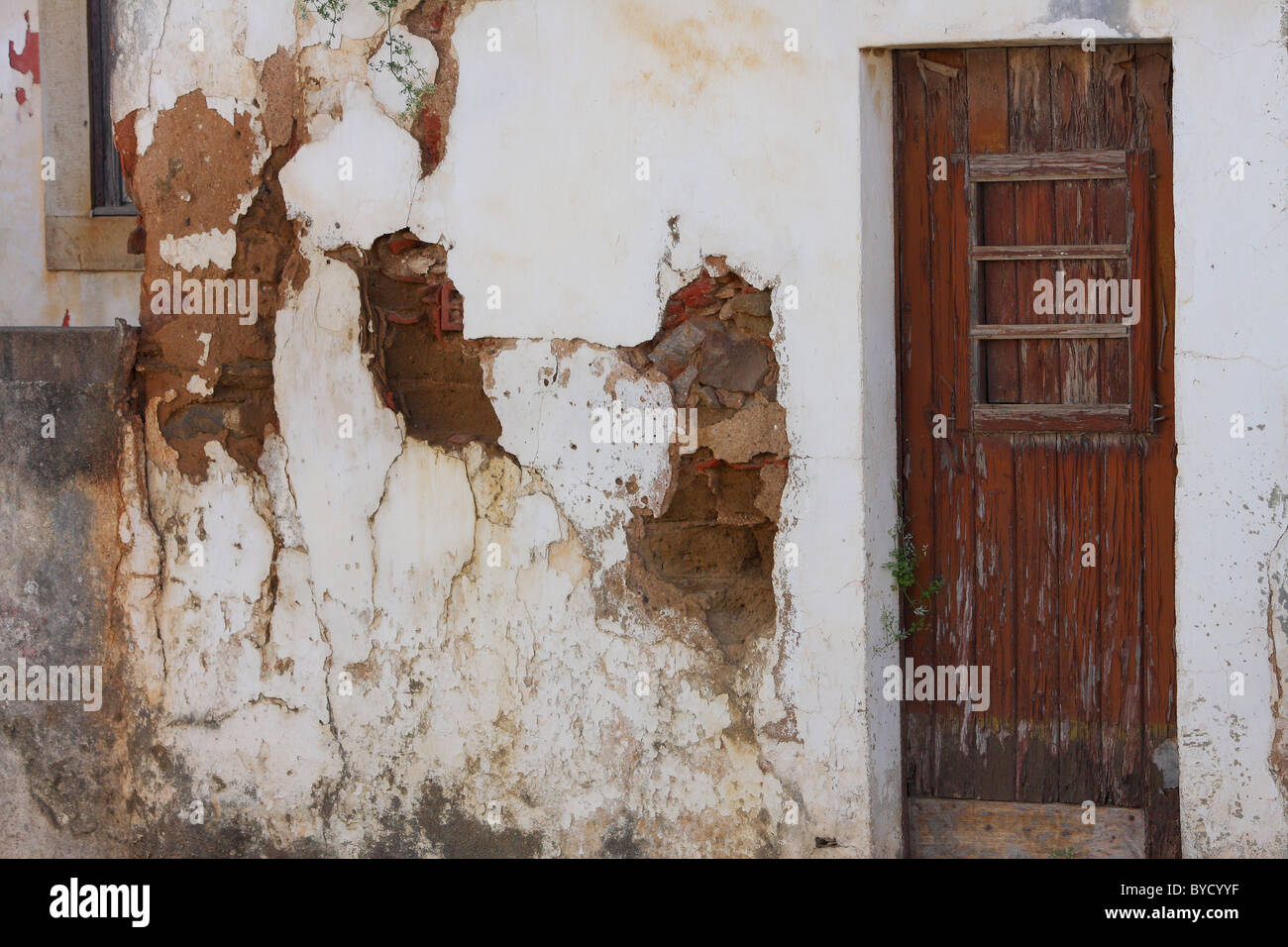 An old poor building where the plaster is falling off the walls Stock Photo