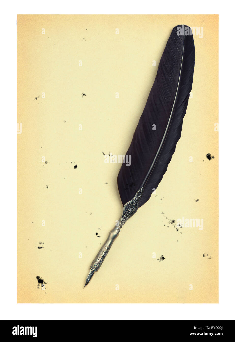 Feather quill on an old paper. Isolated on white.Drops of the sprayed