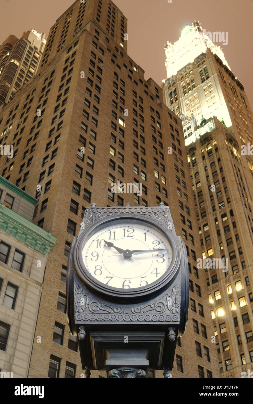 An old fashion clock in downtown Manhattan with skyscrapers behind it. Stock Photo