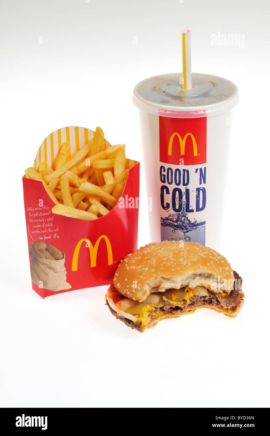 Mcdonald's quarter pounder with cheese with bite taken out, french fries and soda on white background cutout. Stock Photo