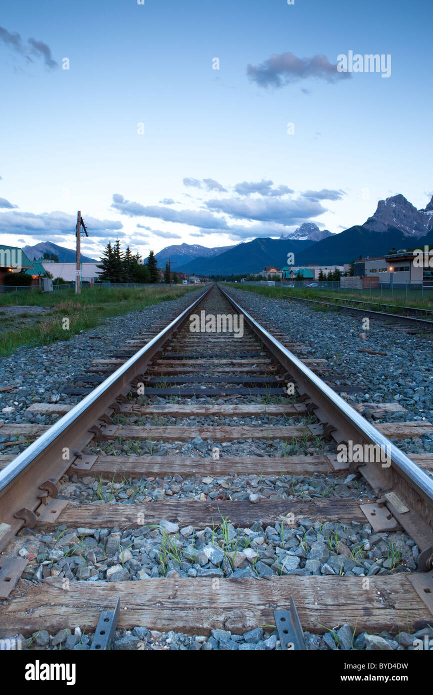 Train tracks running through Canmore, Alberta, Canada.  The first of the Three Sisters peaks can be seen in the distance. Stock Photo
