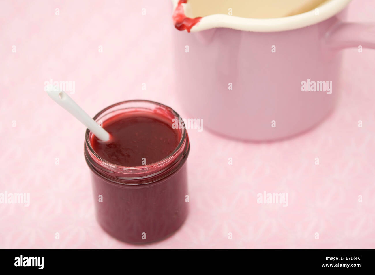 Raspberry jam with spoon and pink pot Stock Photo - Alamy