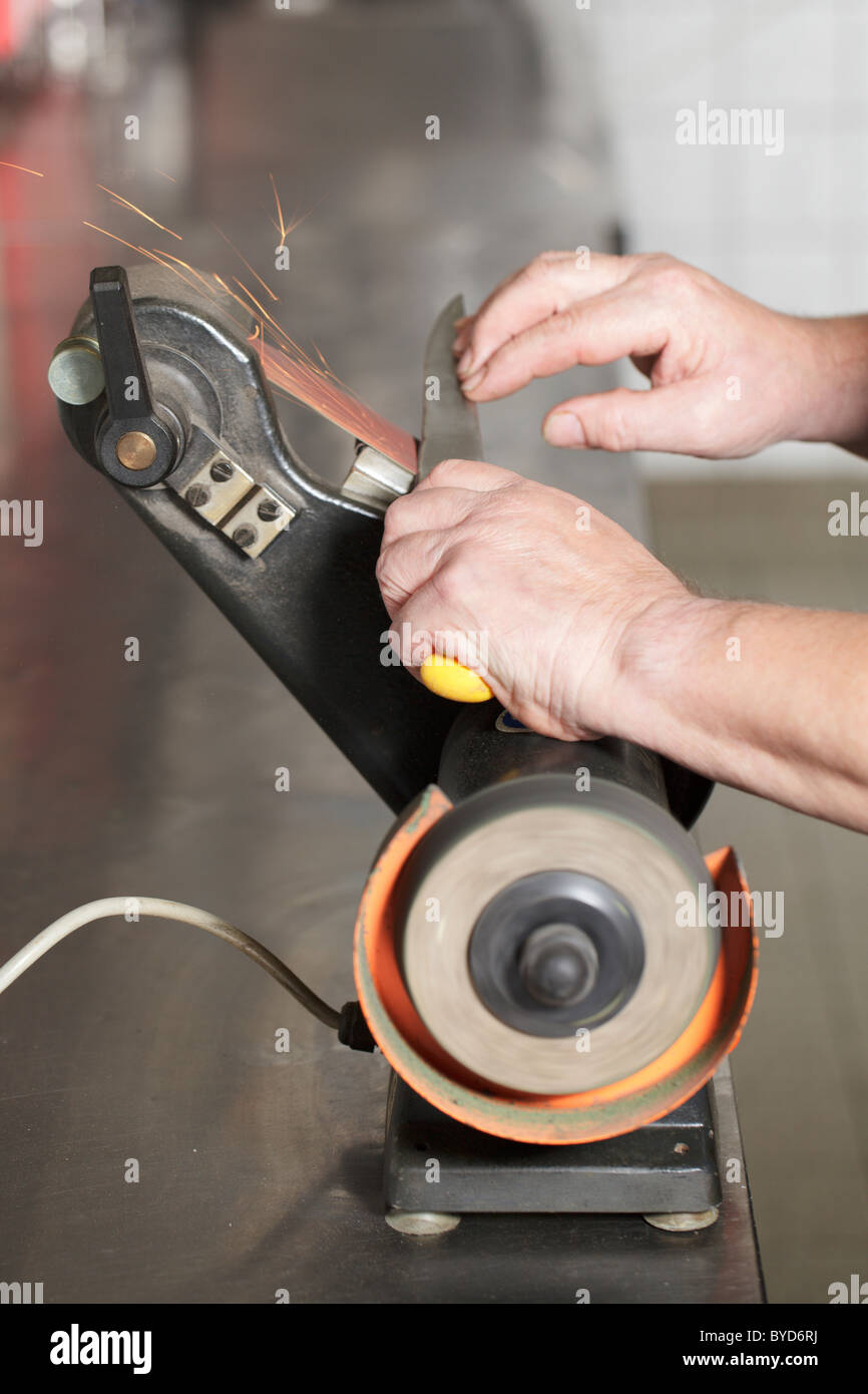 knife sharpening machine and master. Grinding machine. grinding knife using  abrasive stone Stock Photo - Alamy