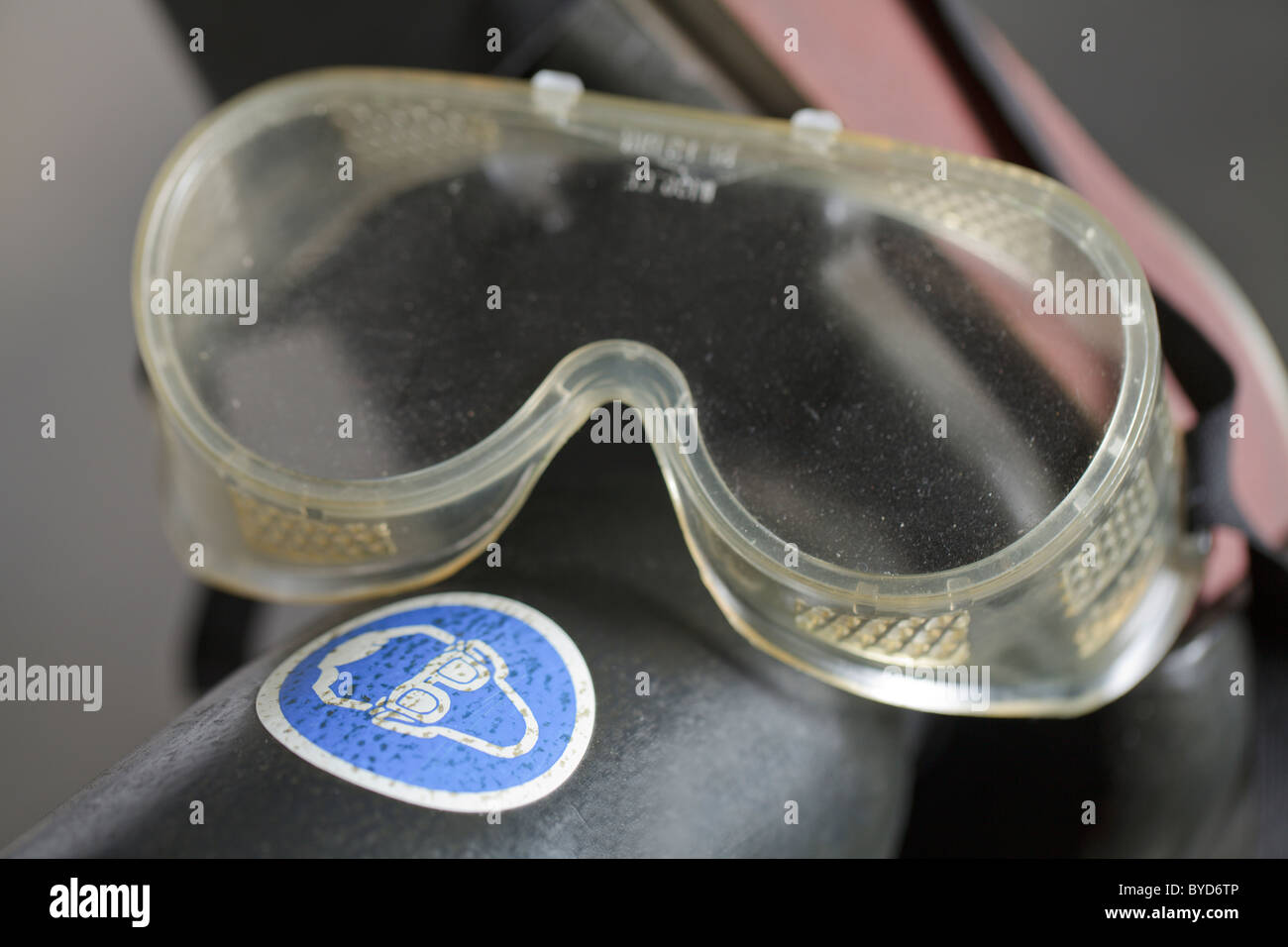 Belt grinder, safety goggles, sign to wear protective goggles Stock Photo