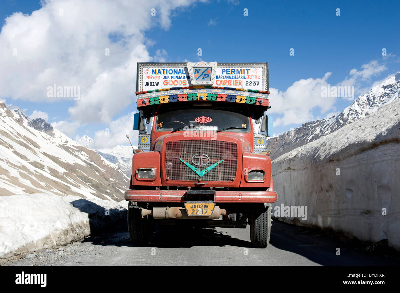 Pass road, Manali-Leh highway, old red Tata truck on road between snow wall near Keylong, Lahaul and Spiti district Stock Photo