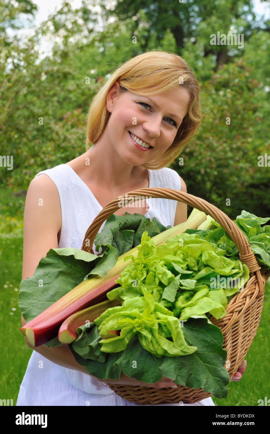 Young woman holding basket with vegetable Stock Photo - Alamy