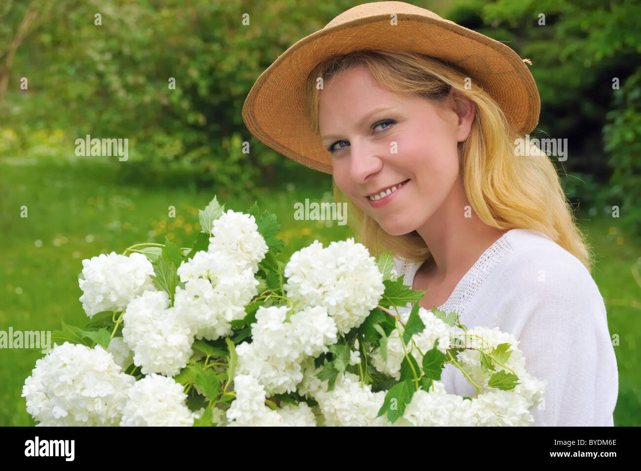 Young woman holding bouquet of flowers Stock Photo - Alamy