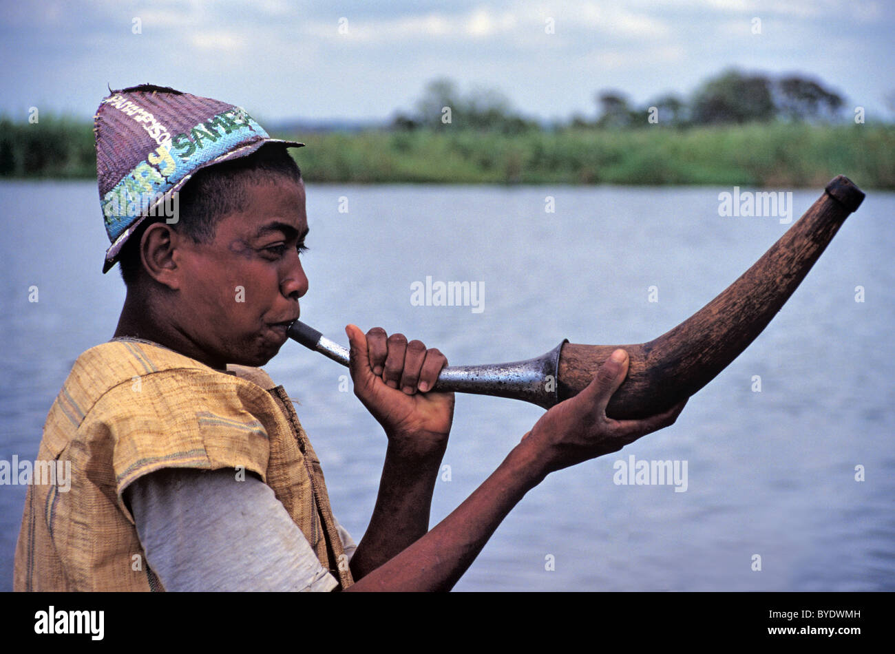 Malagasy Man Playing or Blowing Horn, Horn Player, at Sambatra Circumcision Festival by Pangalanes Canal, Mananjary, Madagascar Stock Photo