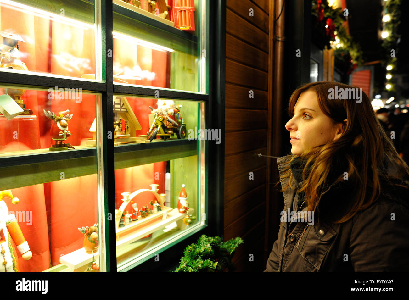 Young woman looking at toys from the Erzgebirge in a display window, Christmas market, Stuttgart, Baden-Wuerttemberg Stock Photo