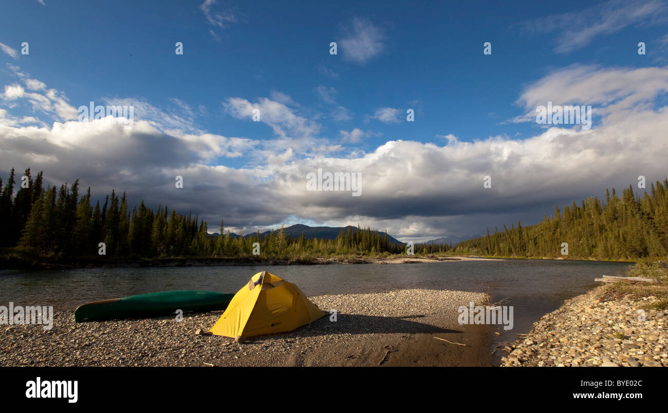 Camp on gravel bar, tent and canoe, Pelly Mountains behind, upper Liard