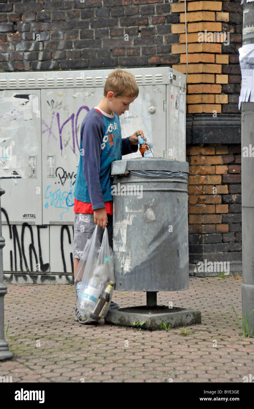 Nine year old boy earning his pocket money by collecting returnable bottles, Germany, Europe Stock Photo