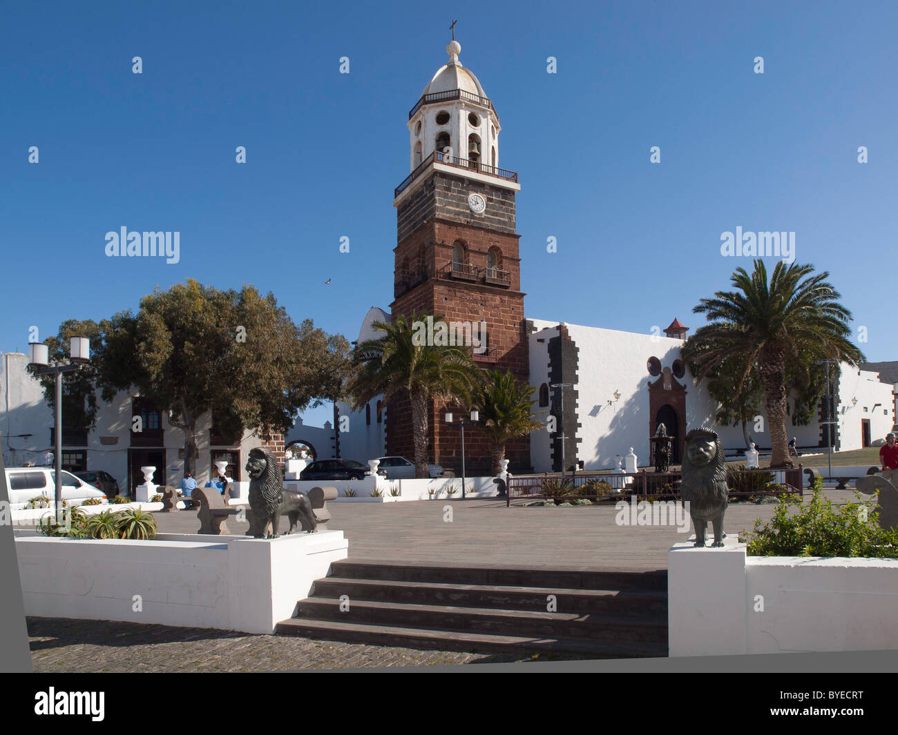 Empty Constitution Square Teguise on a non market day with two bronze lions guarding the 13 century Senora de Guadaloupe church Stock Photo