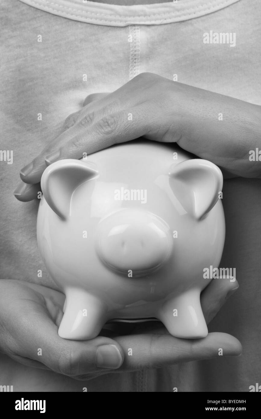 protecting your finances, secure hands around a money box Stock Photo