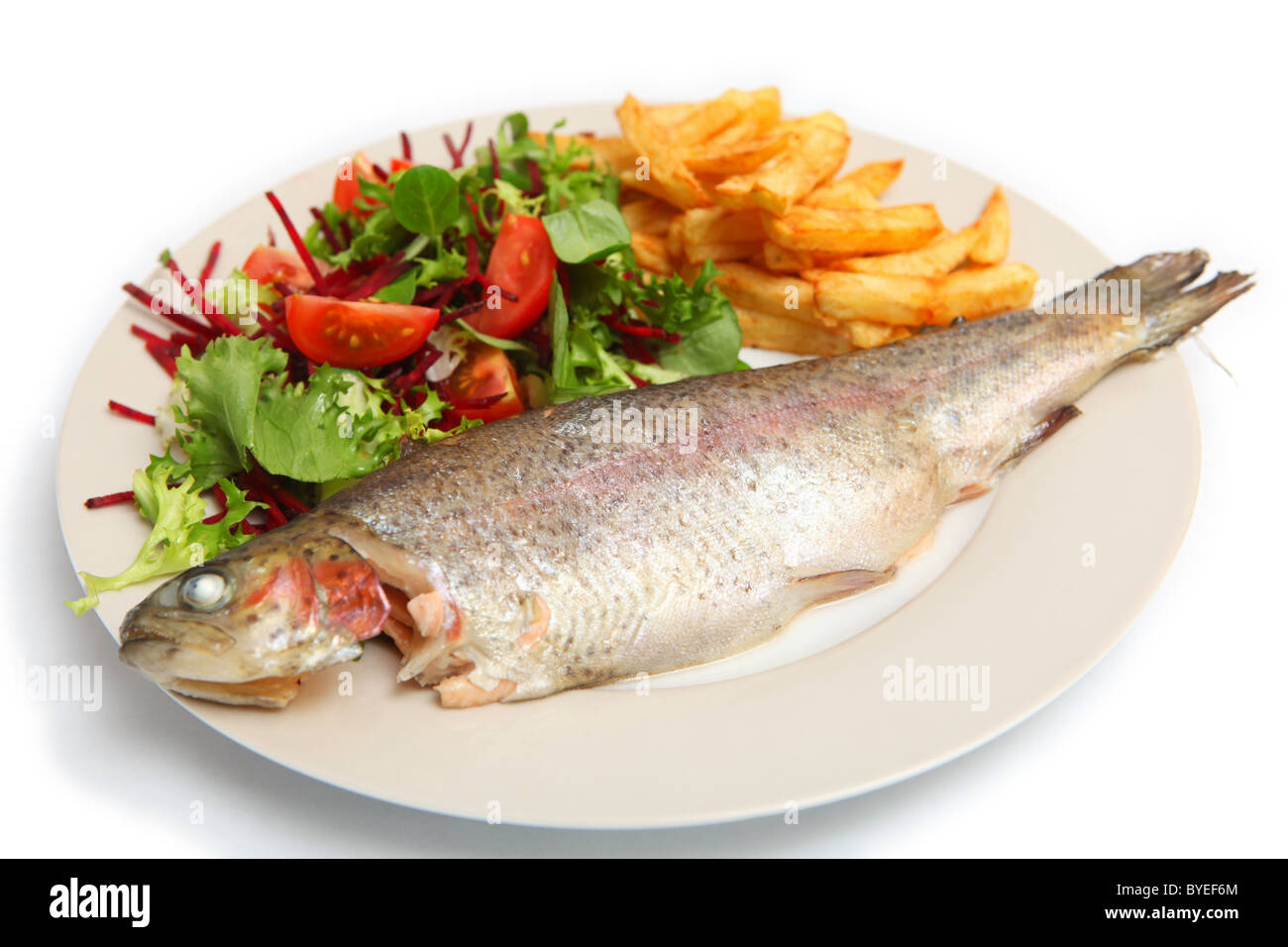 A grilled rainbow trout served with french fries and a salad of lambs